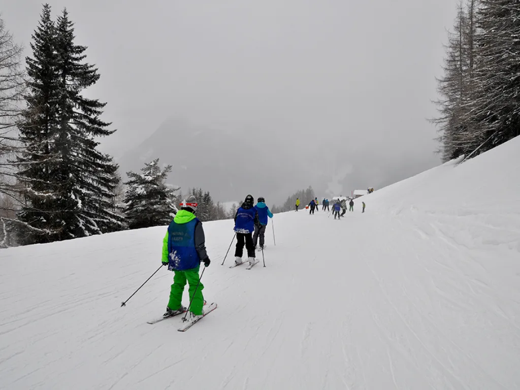 Skifahrende auf einer nebelverhangenen Piste.